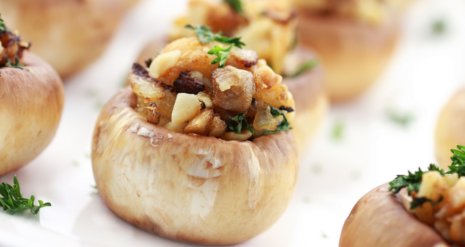 7905667 - stuffed mushrooms filled with bread crumbs, cheese, mushroom stems, fresh parsley,onions and macadamia nuts. extreme shallow dof with selective focus on center mushroom.