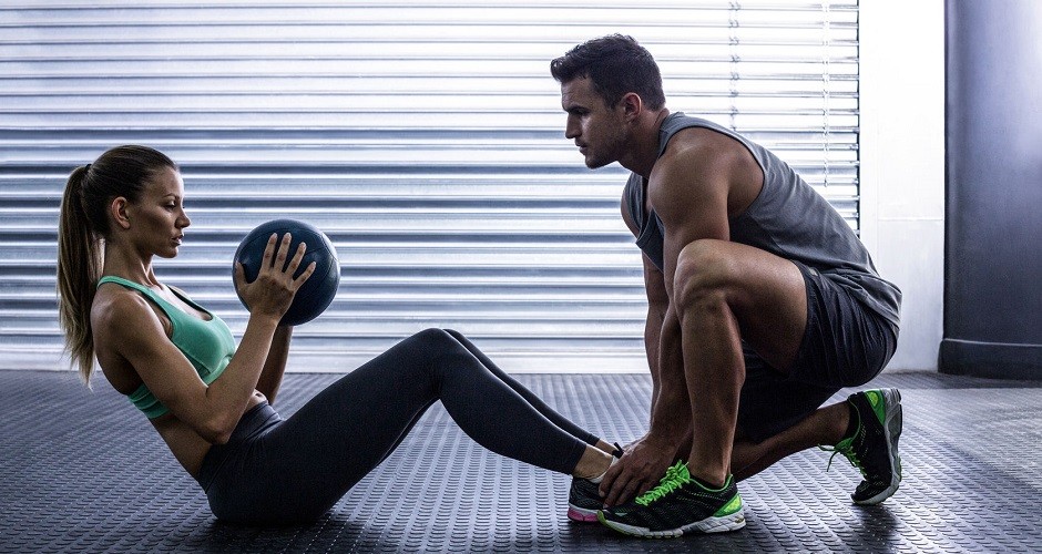 42329550 - side view of a muscular couple doing abdominal ball exercise