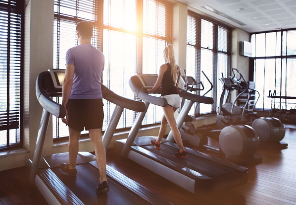 40375927 - healthy man and woman running on a treadmill in a gym. sport and health concept